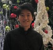 A person standing in front of a christmas tree

Description automatically generated