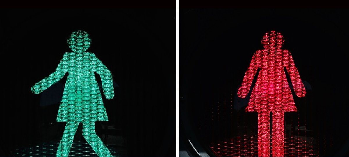 Photo of pedestrian crossing lights, featuring female figures