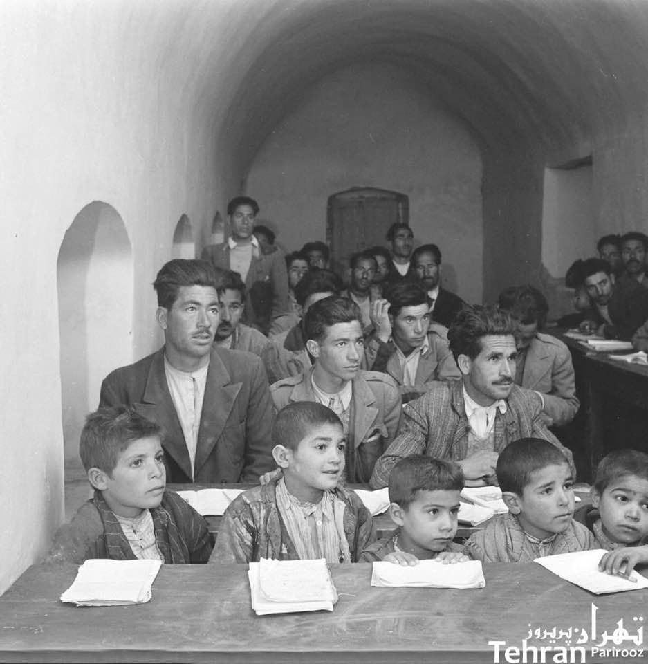 Photo of an evening literacy classroom, with child and adult students