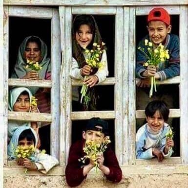 Smiling Iranian children, looking out a window