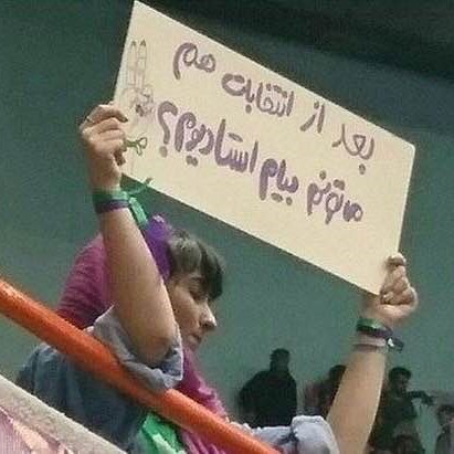 Iranian woman holding a protest sign at an election rally for President Rouhani