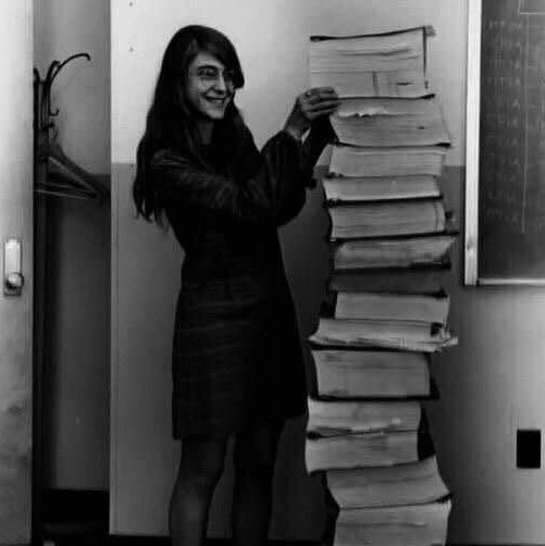 Margaret Hamilton, lead software engineer of the Apollo Project, stands next to the 5-foot-high printout of her hand-produced code, which was responsible for humans landing on the moon in 1969