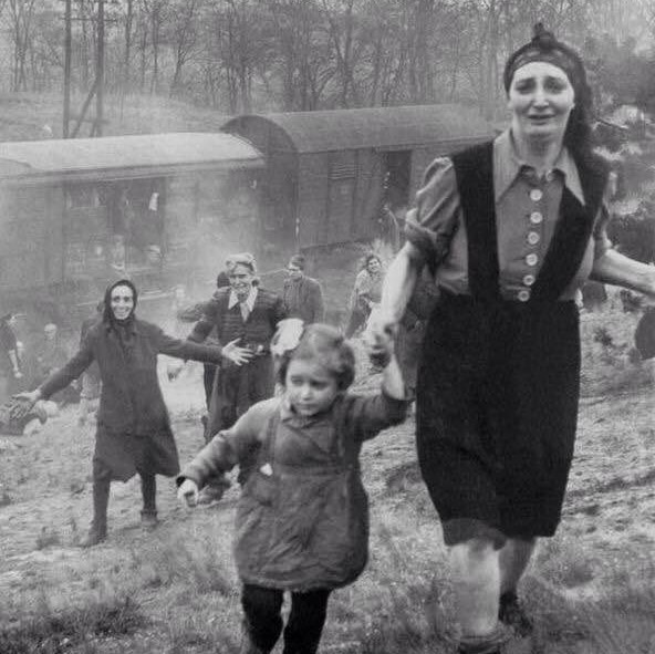 Jewish refugees, as they become aware of their liberation by a group of allied soldiers, 1945