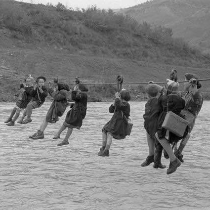 Children cross the river using pulleys on their way to school in the outskirts of Modena, Italy, 1959