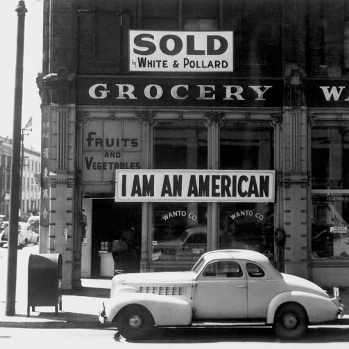 A Japanese-American business owner displays a banner the day after the 1942 Pearl Harbor attack, just before his internment