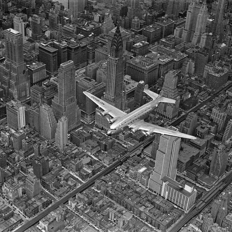 A DC-4 passenger plane flying over midtown Manhattan, 1939