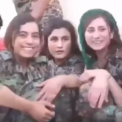 Kurdish fighters smile and dance, as they fight to protect their homeland