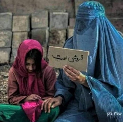 Afghanistan sinking further into despair: A mother holds up a sign indicating that her daughter is for sale